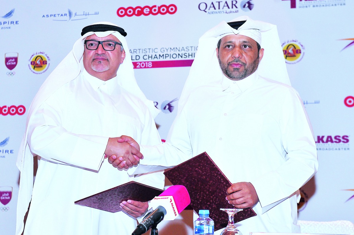 Ali Al Hitmi (left), Qatar Gymnastics Federation (QGF)  and Executive Manager of the 48th Artistic Gymnastics World Championship and Eissa Al Hitmi, Director General of ALKASS exchanging documents during a sponsorship signing ceremony held at Westin Hotel