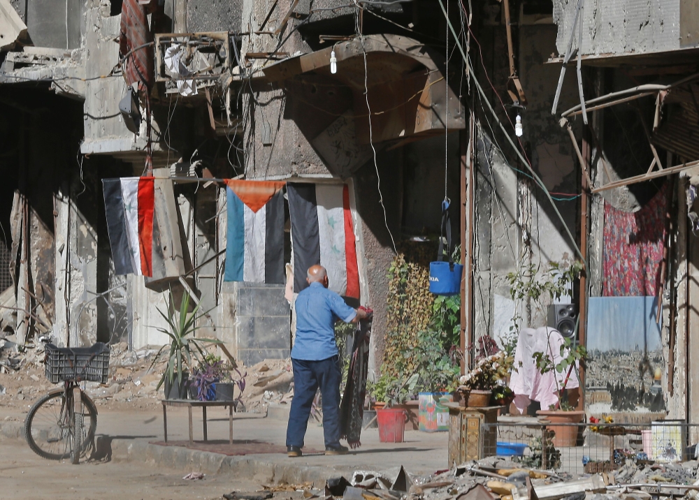 A man stands in a street near destroyed buildings in the Palestinian camp of Yarmuk southern Damascus on November 1, 2018.   AFP / LOUAI BESHARA