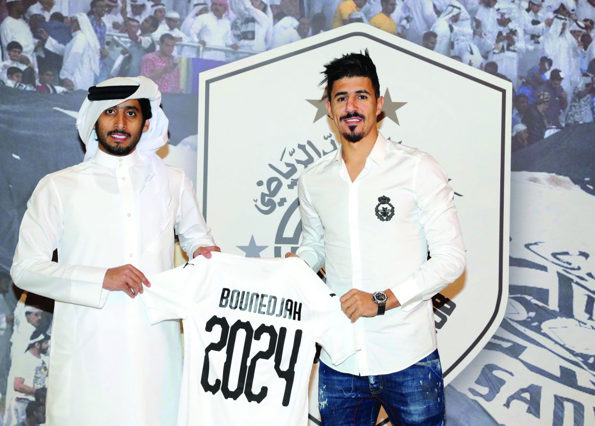 General Manager of the Al Sadd club, Turki Al Ali and Algerian striker Baghdad Bounedjah hold a team jersey after renewing the latter’s contract yesterday.