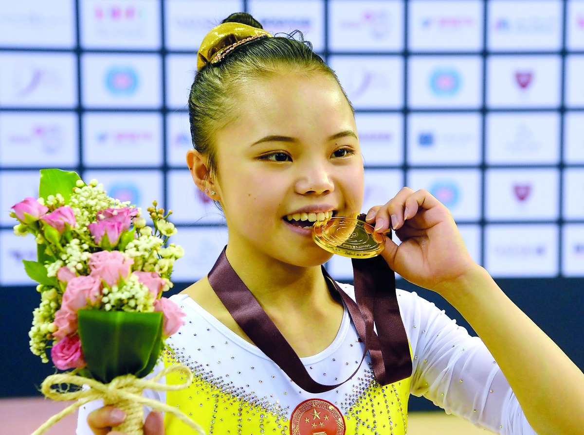 Chinese teenager Li Qi celebrates with her gold medal after winning the Balance Beam yesterday. 