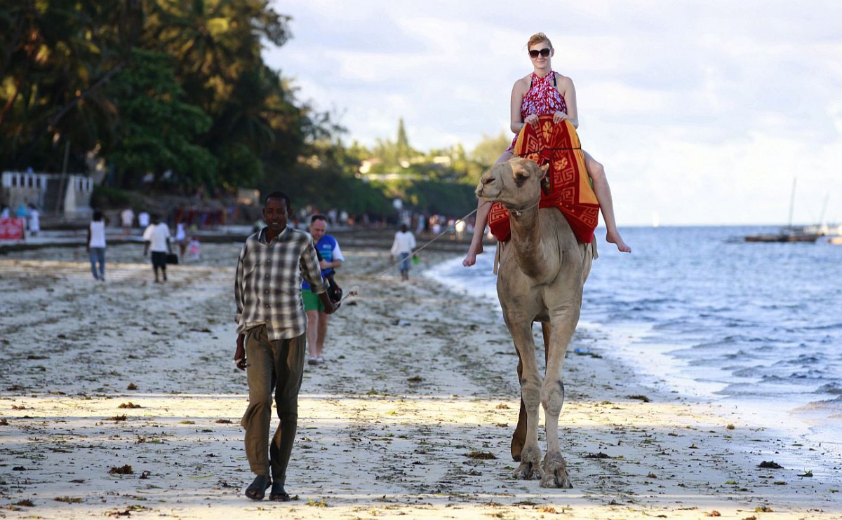 A tourist rides on camel back at the Jomo Kenyatta public beach in coastal city of Mombasa, Kenya, March 24, 2013. Reuters / Joseph Okanga