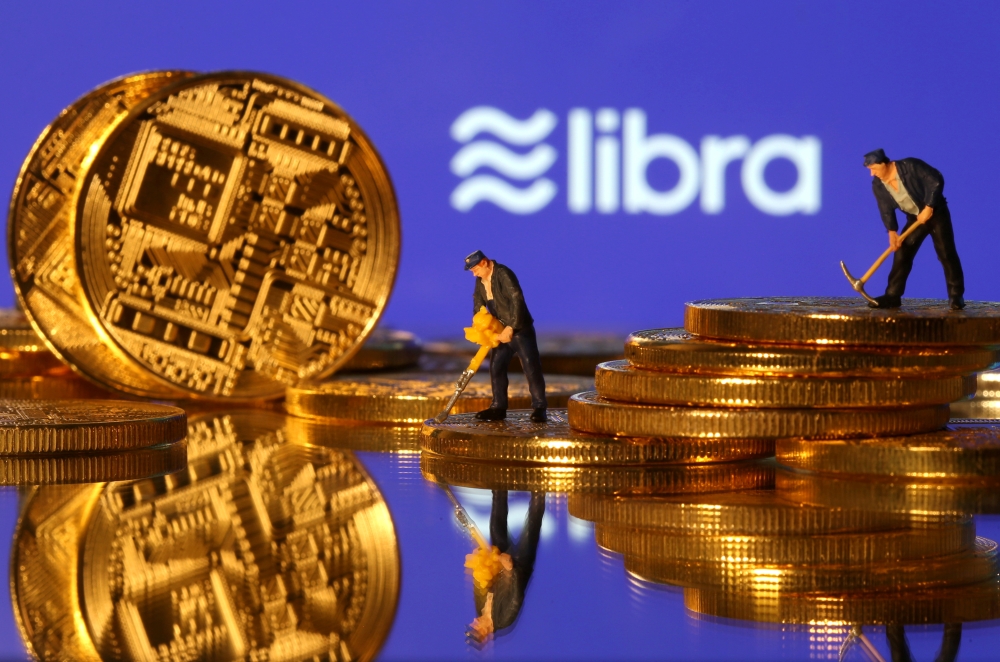 FILE PHOTO: Small toy figures are seen on representations of virtual currency in front of the Libra logo in this illustration picture, June 21, 2019. REUTERS/Dado Ruvic/Illustration