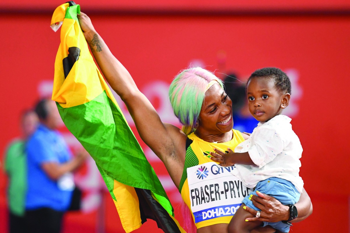 Fraser-Pryce holds her son Zyon after the race.