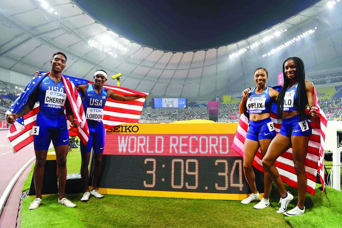 USA's Michael Cherry, USA's Wilbert London, USA's Allyson Felix and USA's Courtney Okolo react after setting a world record in the Mixed 4 x 400m Relay final at the 2019 IAAF World Athletics Championships at the Khalifa International Stadium in Doha on Se