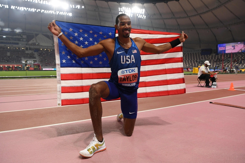 USA's Christian Taylor celebrates with the national flag after winning the Men's Triple Jump final at the 2019 IAAF World Athletics Championships at the Khalifa International Stadium in Doha on September 29, 2019. (AFP / Kirill KUDRYAVTSEV)