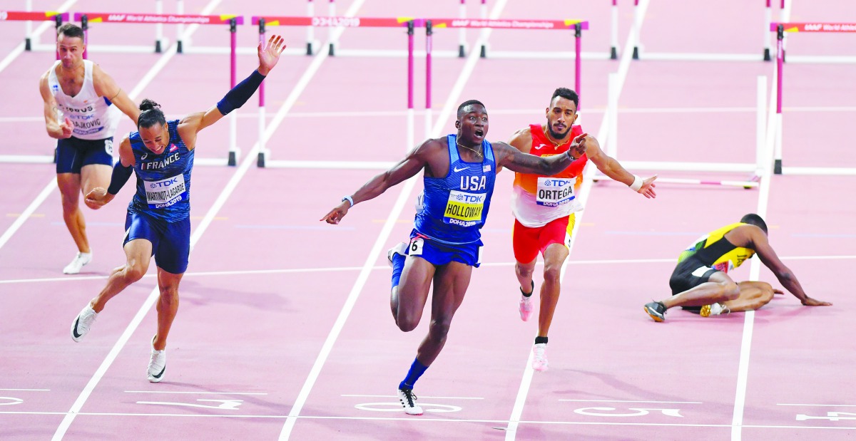 USA’s Grant Holloway (centre) wins the  men’s 110 hurdles final as Jamaica’s Omar Mcleod (right) lies on the track. Picture: Abdul basit / The Peninsula