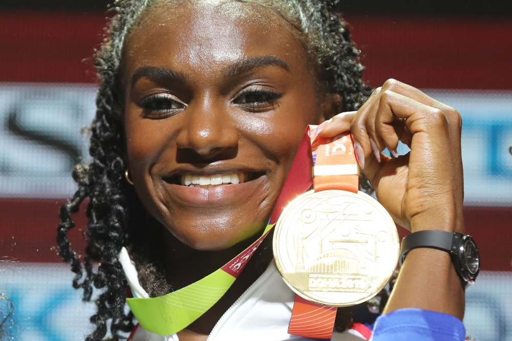 Gold medallist Britain's Dina Asher-Smith poses on the podium during the medal ceremony for the Women's 200m at the 2019 IAAF World Athletics Championships in Doha on October 3, 2019. / AFP / KARIM JAAFAR 