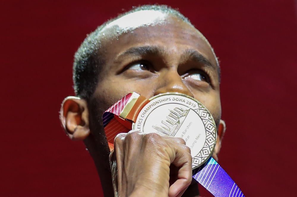 File photo of gold medallist Qatar's Mutaz Essa Barshim poses on the podium during the medal ceremony for the Men's High Jump at the 2019 IAAF Athletics World Championships at the Khalifa International stadium in Doha on October 5, 2019. / AFP / MUSTAFA A