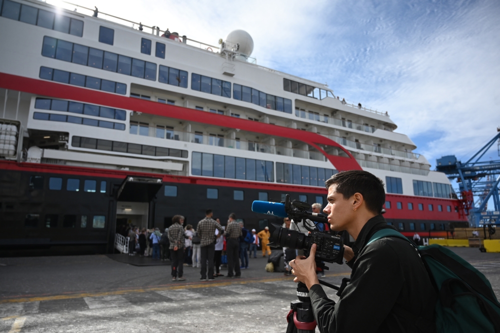 AFP video jounalist Viken Kantarci works before boarding the Hurtigruten hybrid expedition cruise ship, MS Roald Amundsen, in Valparaiso, Chile, on October 27, 2019. AFP / Johan Ordonez