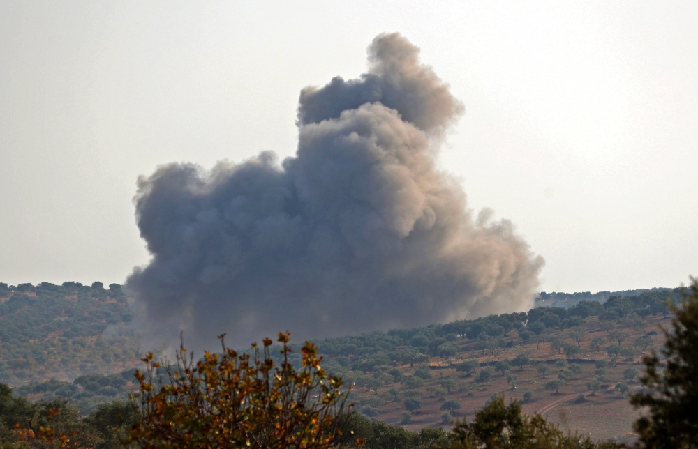 FILE PHOTO: Smoke billows during reported airstrikes by Syrian pro-regime forces on the village of Bsaqla, in the southern countryside of Idlib province, on November 26, 2019. / AFP / Omar HAJ KADOUR