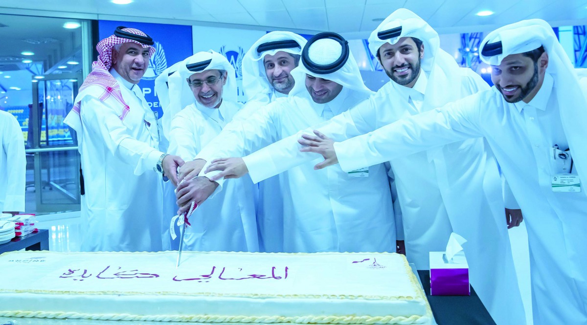 Aspire Zone Foundation staff cutting a cake during Qatar National Day celebrations.