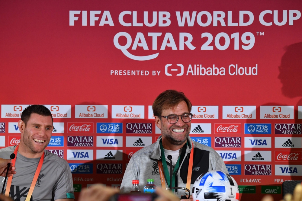 Liverpool FC coach Jurgen Klopp (C) and midfielder James Milner (L) give a press conference on the eve of their 2019 FIFA Club World Cup semi-final match against Monterrey, in Doha on December 17, 2019. / AFP / GIUSEPPE CACACE