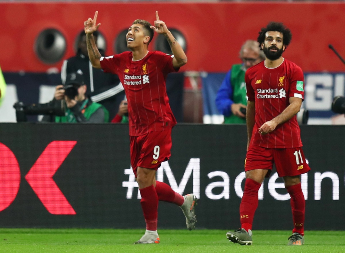 Liverpool’s Roberto Firmino (left) celebrates scoring their second goal with Mohamed Salah on Wednesday in Doha.
