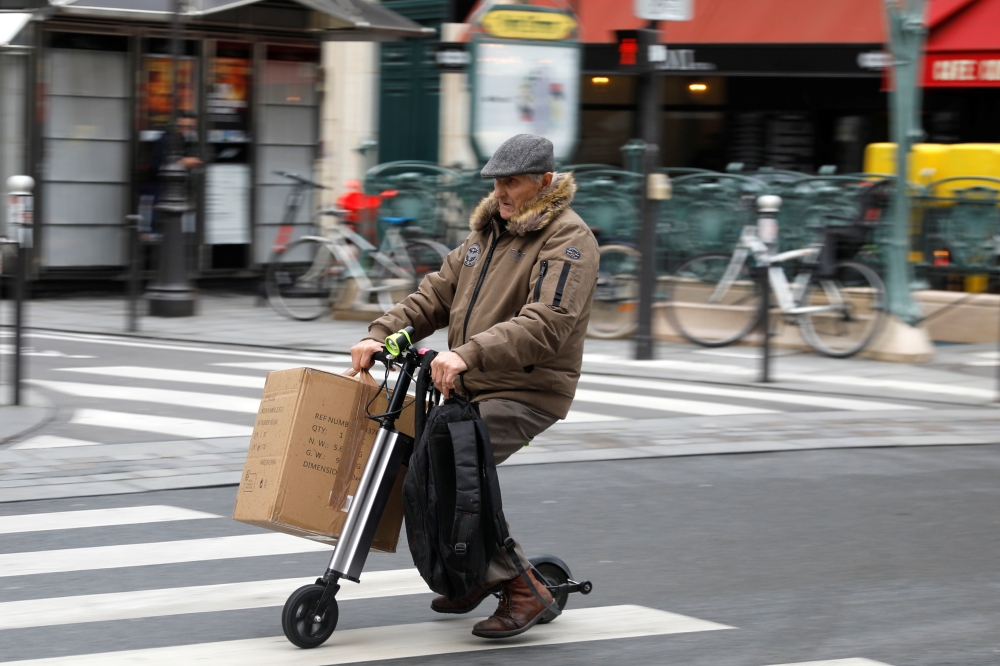 A man rides an electric scooter or 