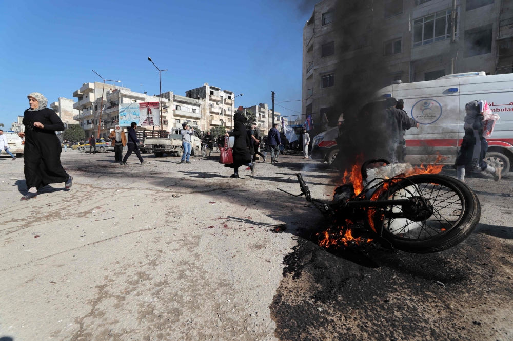 Panicked residents run following an air strike by pro-regime forces in the nothwestern Syrian city of Idlib on January 11, 2020. / AFP / Omar HAJ KADOUR