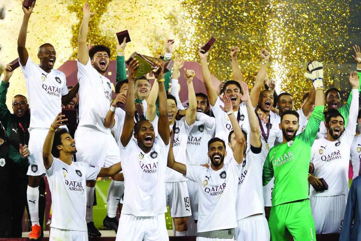 Al Sadd's players celebrate with their Qatar Cup trophy yesterday.