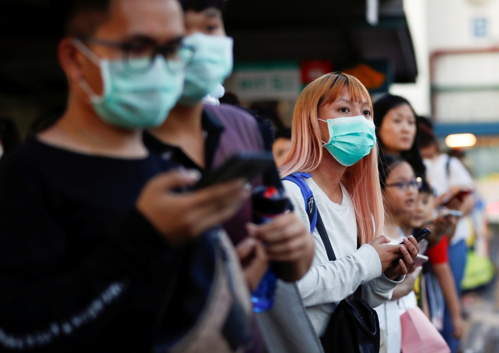 Commuters wait for a transport to leave the Woodlands Causeway across to Singapore from Johor, hours before Malaysia imposes a lockdown on travel due to the coronavirus outbreak March 17, 2020. Reuters/Edgar Su