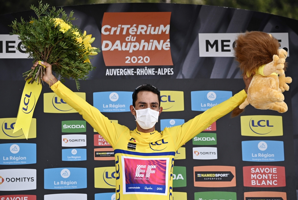 Team Education First rider Colombia's Daniel Martinez celebrates his overall leader's yellow jersey on the podium at the end of the fifth stage of the 72nd edition of the Criterium du Dauphine cycling race, 153 km between Megeve and Megeve on August 16, 2