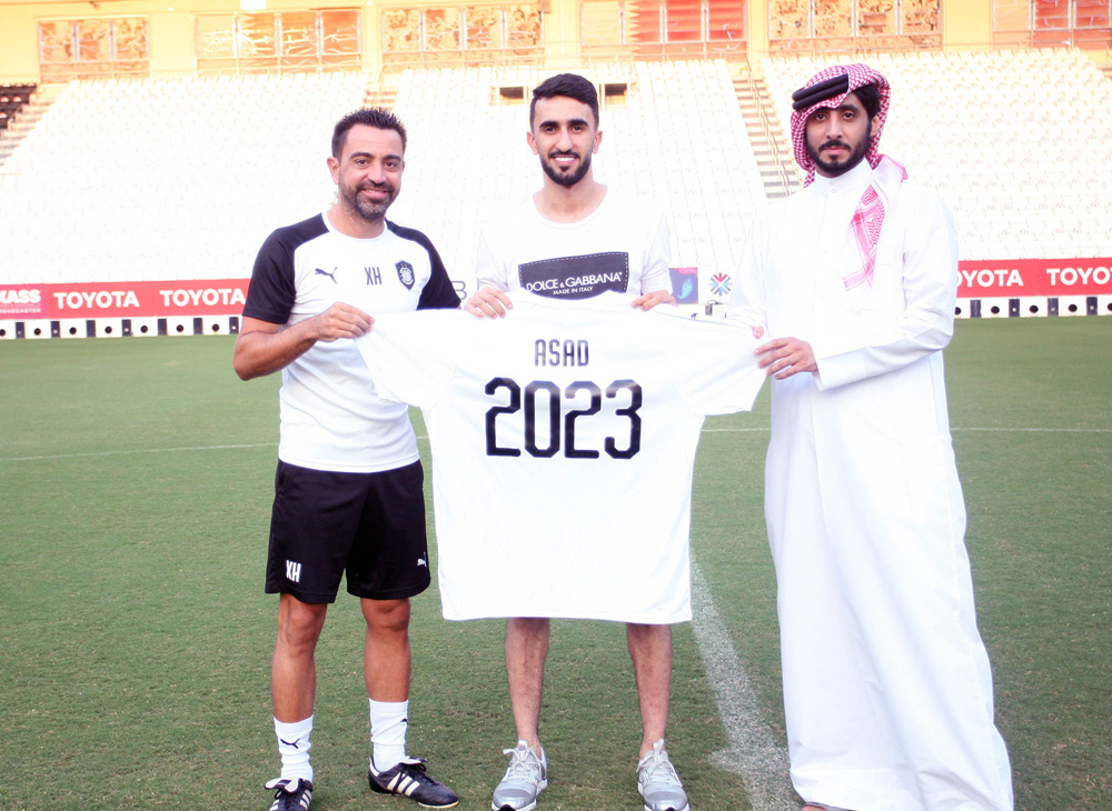 Al Sadd's coach Xavi, Ali Asad and the Club's General Manager Turki Nasser Al Ali posing for a photograph after signing the contract.