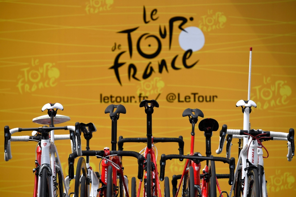 In this file photo taken on July 4, 2017, the official logo of the Tour de France is pictured behind bikes prior to the 207,5 km fourth stage of the 104th edition of the Tour de France cycling race between Mondorf-les-Bains and Vittel. / AFP / Lionel BONA