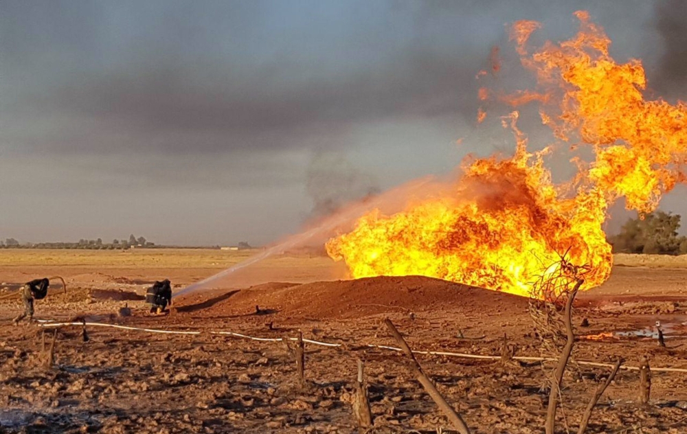 Syrian firefighters putting out a burning pipeline between the areas of Adra and al-Dhamir in the Damascus area. A suspected attack on a pipeline in Syria caused a nationwide blackout overnight, the state news agency quoted authorities as saying.