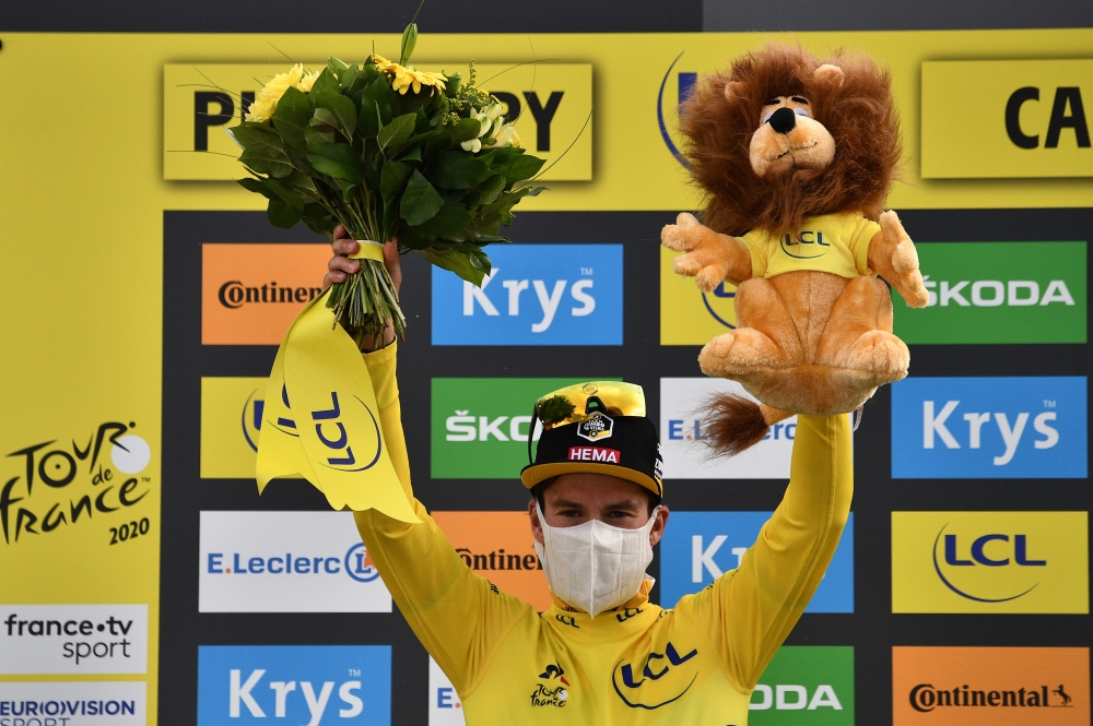 September 11, 2020. Team Jumbo-Visma rider Primoz Roglic of Slovenia, wearing the overall leader's yellow jersey, celebrates on the podium. Pool via REUTERS/Anne-Christine Poujoulat