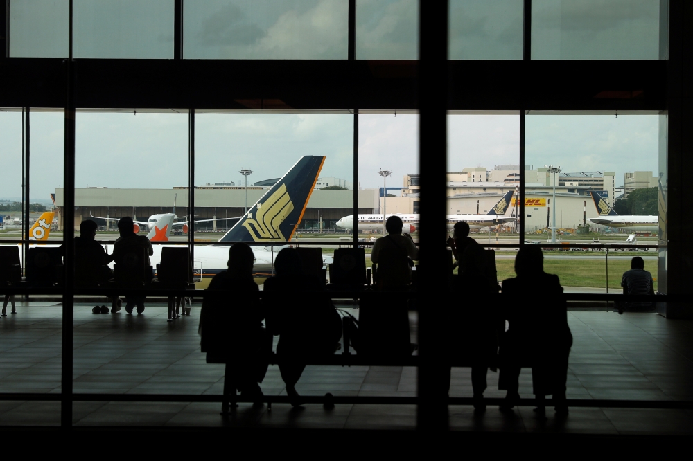 People look at a Singapore Airlines plane, amid the spread of the coronavirus disease (COVID-19), at a viewing gallery of the Changi Airport in Singapore October 12, 2020. REUTERS/Edgar Su