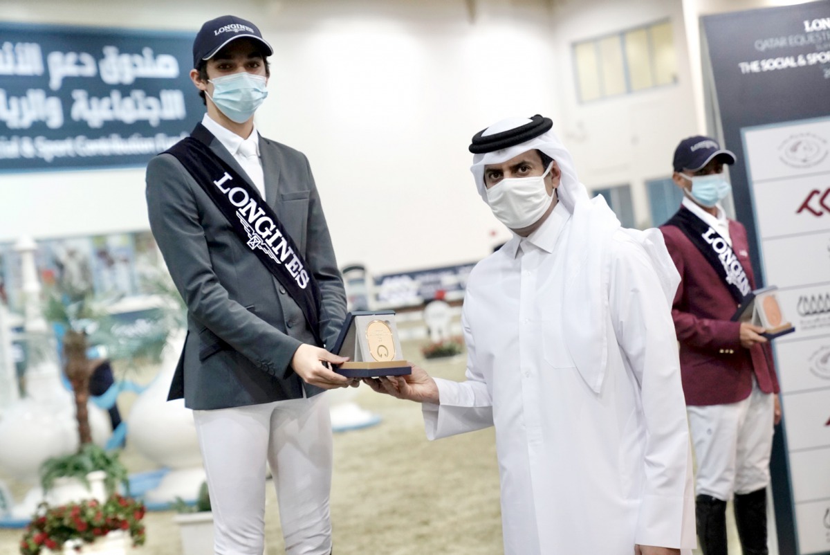 Khalifa Abdulla Al Khaldi receiving the Small Tour winner's trophy on the opening day of the second round of the Fourth Longines Hathab Equestrian Series at Qatar Equestrian Federation’s Indoor Arena yesterday