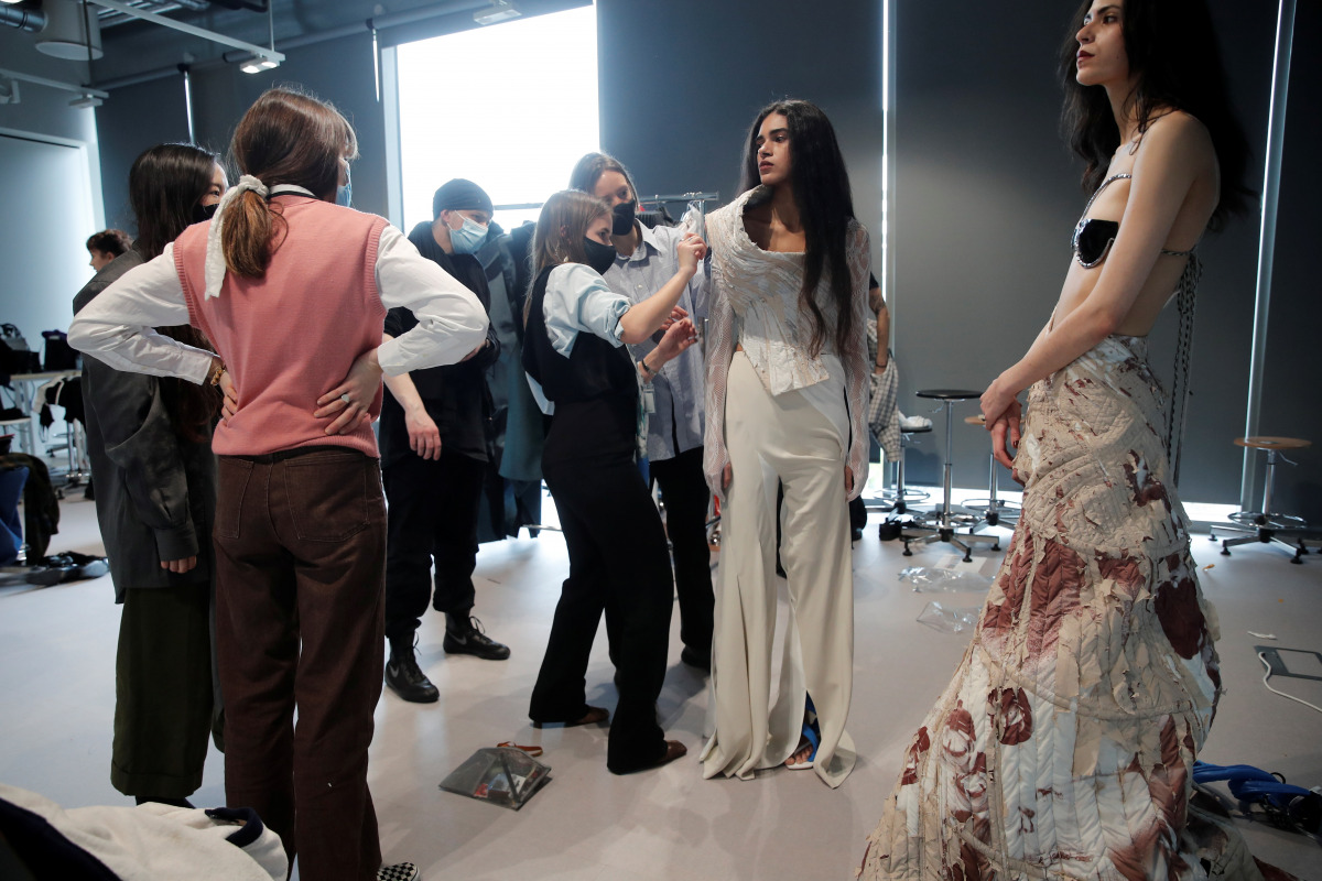 A model has her outfit adjusted backstage before a digital fashion show by a fashion design student at the Institut Francais de la Mode as part of the Women's Fashion Week in Paris, France, February 20, 2021. Picture taken February 20, 2021. REUTERS/Benoi