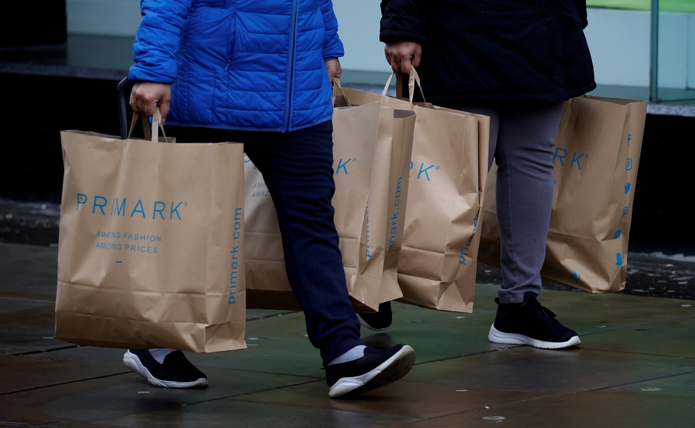 Shoppers carry bags from Primark at the start of the Boxing Day sales amid the outbreak of the coronavirus disease (COVID-19) in Manchester, Britain, December 26, 2020. REUTERS/Phil Noble/File Photo