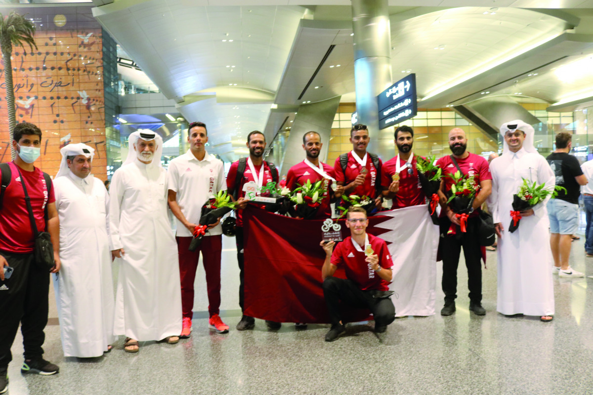 Qatar cyclists and officials pose for a photograph at the Hamad International Airport.