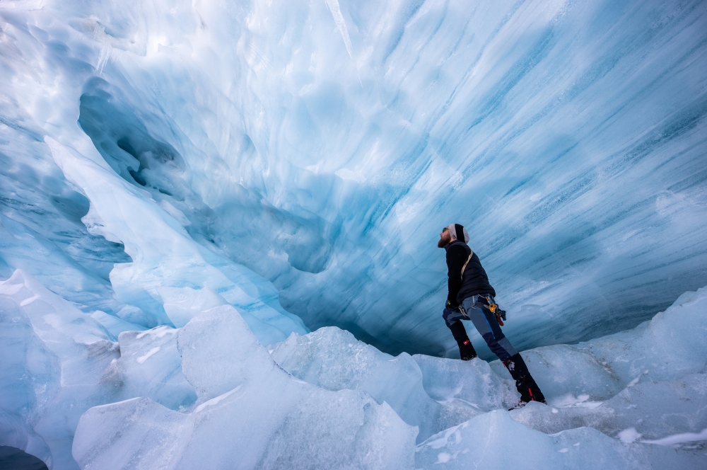 Glaciologist Martin Stocker-Waldhuber, from the Austrian Academy of Sciences, explores a natural glacier cavity of the Jamtalferner glacier near Galtuer, Austria, October 15, 2021. Giant ice caves have appeared in glaciers accelerating the melting process