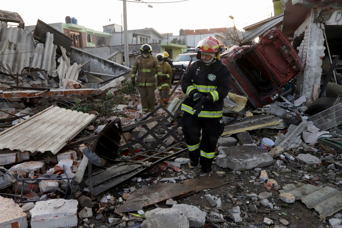 Firefighters walk at an area affected by the explosion of a gas leak caused by a pipeline theft, in the San Pablo Xochimehuacan neighborhood in Puebla, Mexico October 31, 2021. REUTERS/Imelda Medina