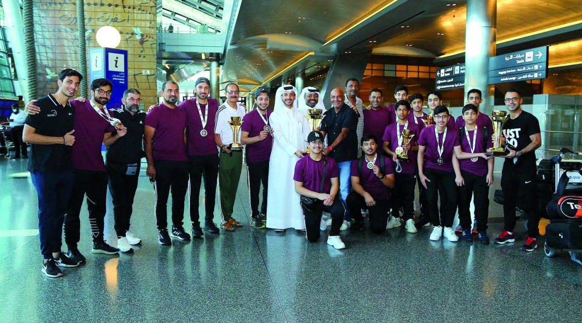 Qatar squash team players and officials pose for a photograph upon their arrival in Doha.