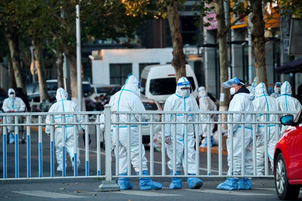 Security personnel in protective suits guard the perimeter of a residential compound locked down after a local outbreak of the coronavirus disease (COVID-19) in Beijing, China, November 11, 2021. Reuters/Thomas Peter/File Photo
 