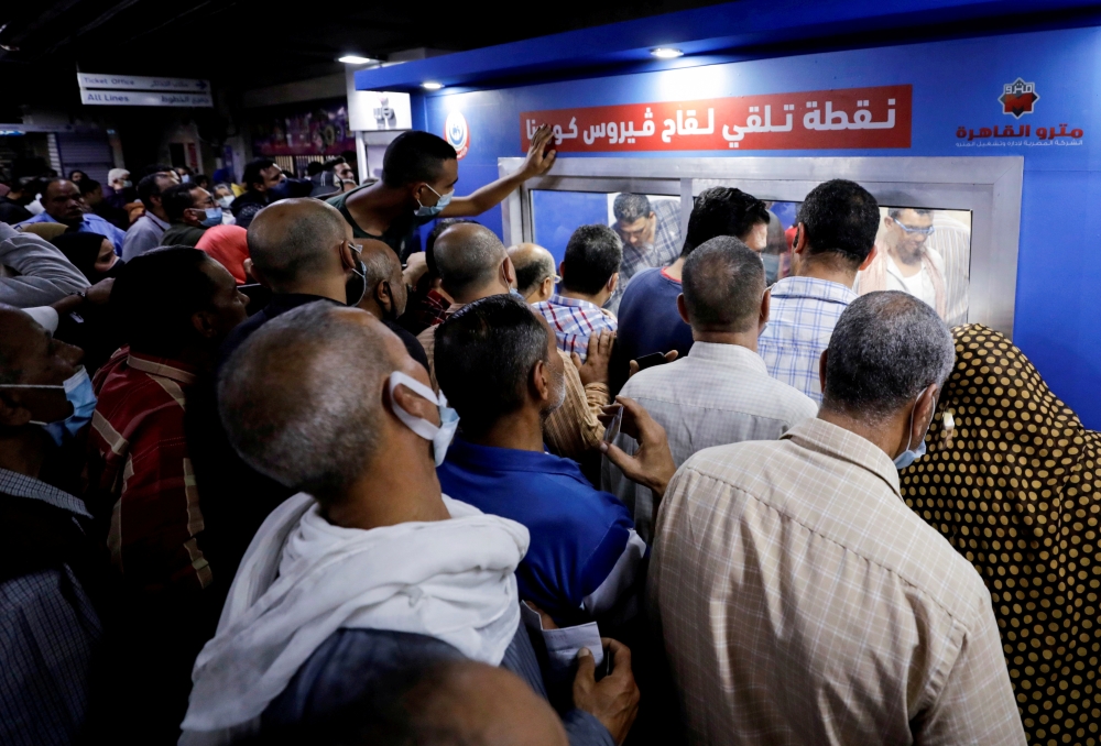 People wait to receive a dose of the coronavirus disease (COVID-19) vaccine at an immediate vaccination center operating at the Sadat underground metro station, in Cairo, Egypt, November 14, 2021. REUTERS/Mohamed Abd El Ghany