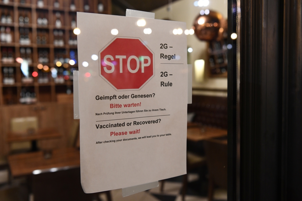 A '2G' rule sign, allowing only those vaccinated or recovered from the coronavirus disease (COVID-19) to enter restaurants and other indoor areas, is displayed at the entrance of a restaurant in Berlin, Germany, November 15, 2021. REUTERS/Annegret Hilse
