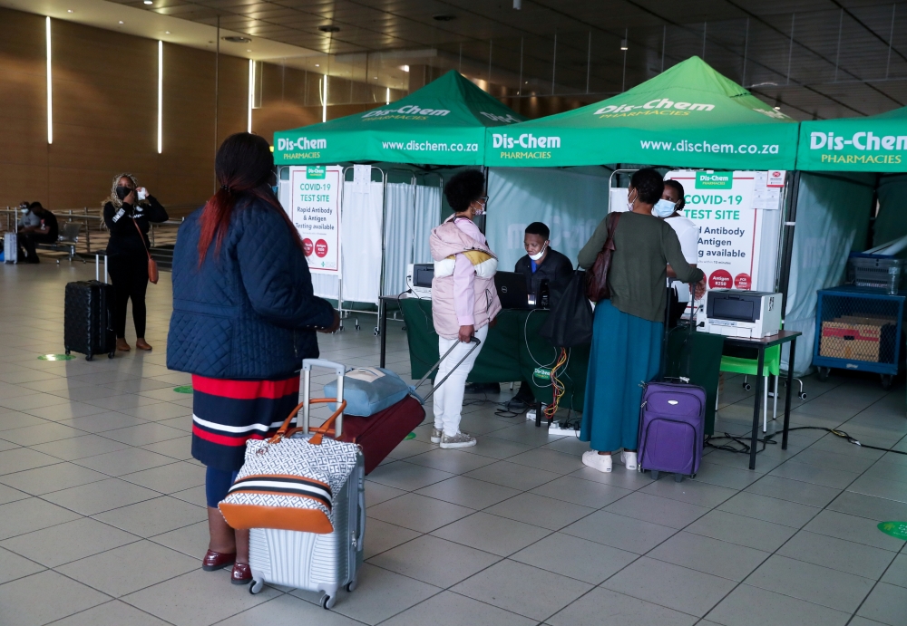 FILE PHOTO: Passengers queue to get a PCR test against the coronavirus disease (COVID-19) before traveling on international flights, at O.R. Tambo International Airport in Johannesburg, South Africa, November 26, 2021. REUTERS/Sumaya Hisham
