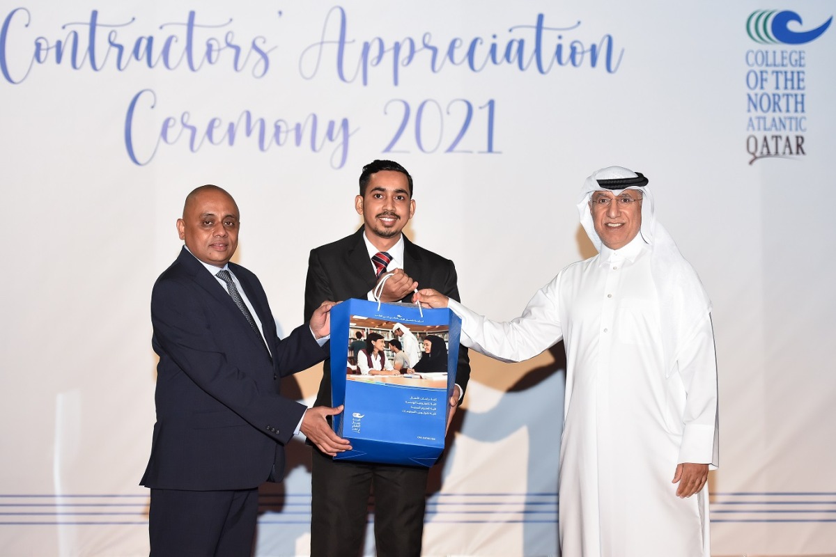 CNA-Q President Dr. Salem Al Naemi handing over a prize to an employee.  