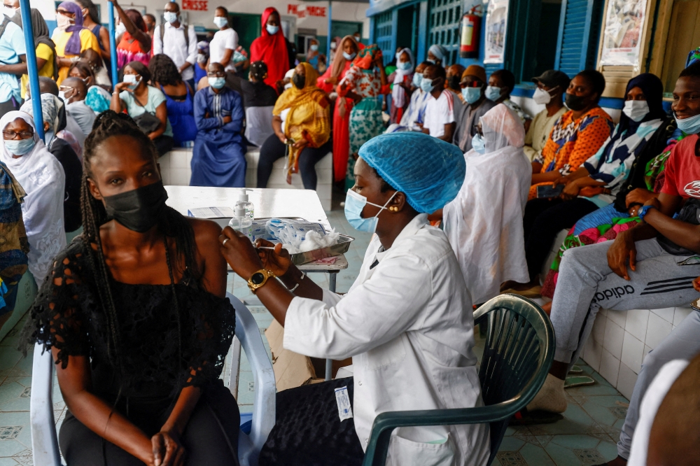 Aminata Laye Diagne, a nurse gives a dose of coronavirus disease (COVID-19) vaccine to a woman at Philippe Senghor Hospital in Dakar, amid a surge of coronavirus disease (COVID-19) cases in Senegal July 28, 2021. REUTERS/Zohra Bensemra/File Photo