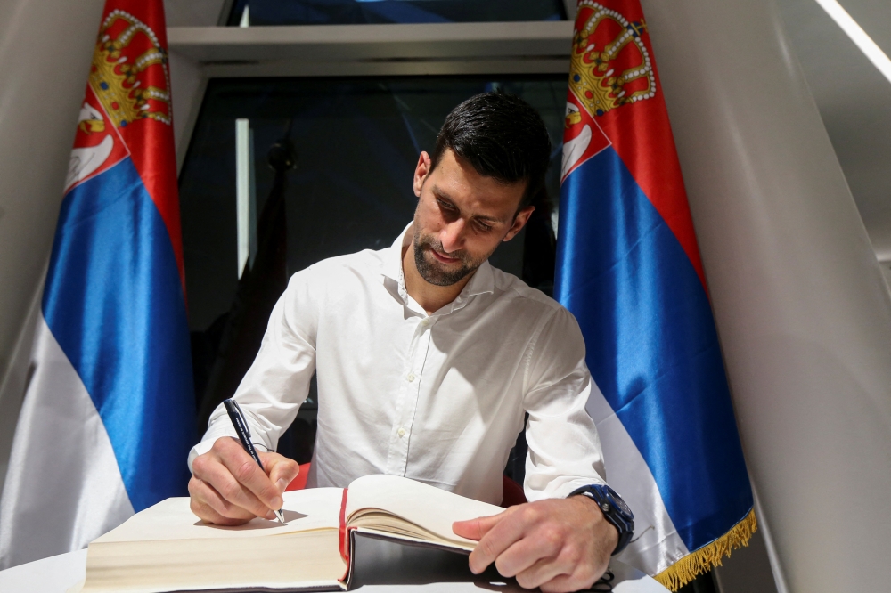 Tennis player Novak Djokovic signs the honour book as he visits the Serbia pavilion at Expo 2020 for the presentation of the Novak Djokovic Foundation, in Dubai, United Arab Emirates, February 17, 2022. REUTERS/Satish Kumar