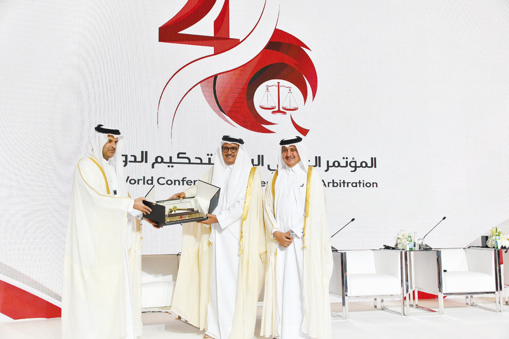 Minister of Justice H E Masoud bin Mohamed Al Ameri (centre) receives an award from QICCA Board Member for International Relations Dr Sheikh Thani bin Ali Al Thani, as QC and QICCA Chairman Sheikh Khalifa bin Jassim Al Thani looks on, at the opening of the 4th World Conference on International Arbitration at The Ritz-Carlton, Doha, yesterday. 