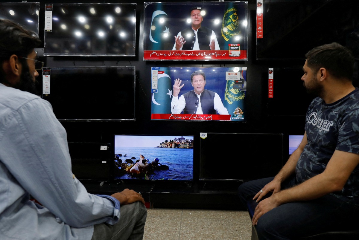 People watch the speech of Pakistani Prime Minister Imran Khan on television screens, in Islamabad, Pakistan, March 31, 2022. REUTERS/Akhtar Soomro
