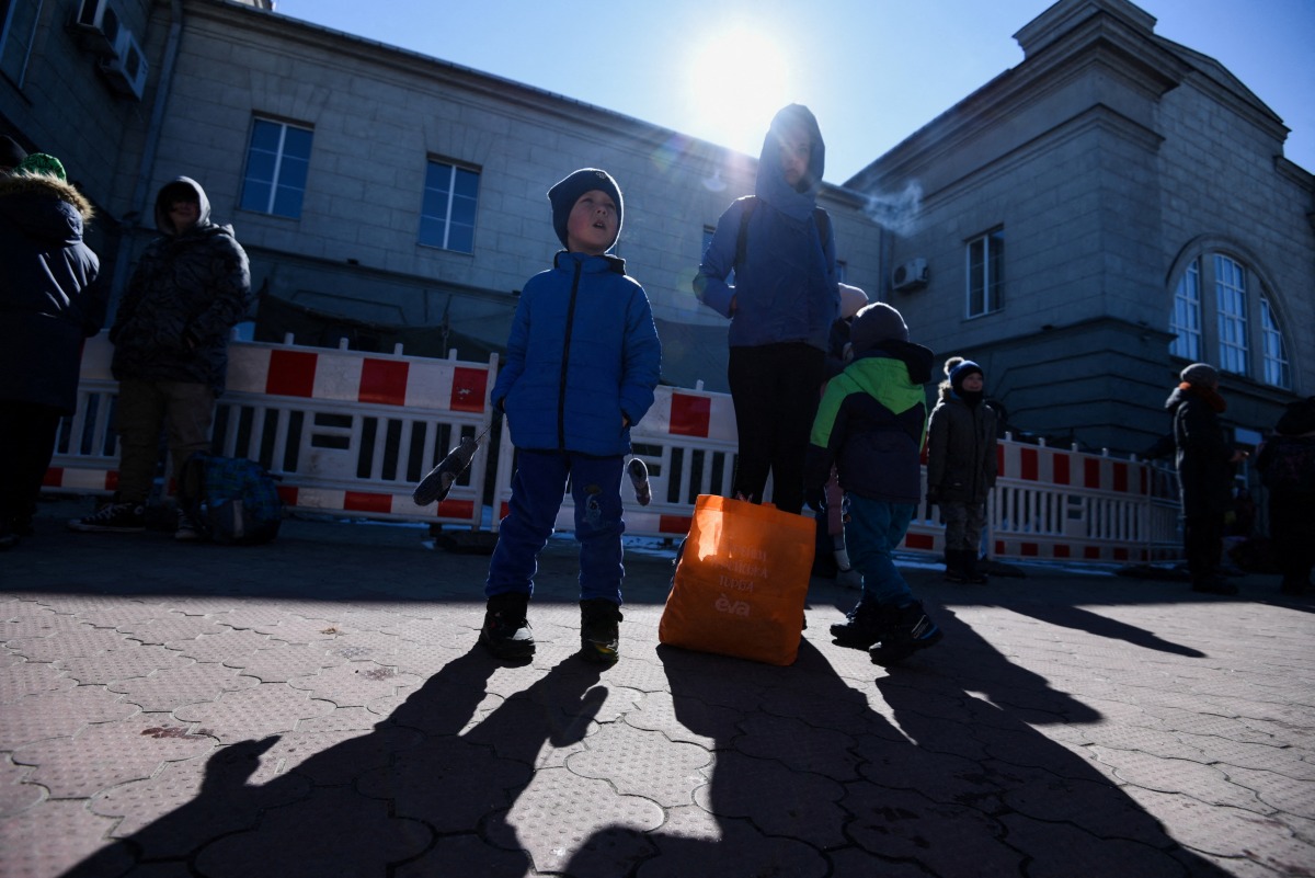 FILE PHOTO: People with children wait at the train station during an evacuation of women, children and people with disabilities, amid Russia's invasion of Ukraine, in Dnipro, Ukraine March 12, 2022. REUTERS/Mykola Synelnikov/File Photo
