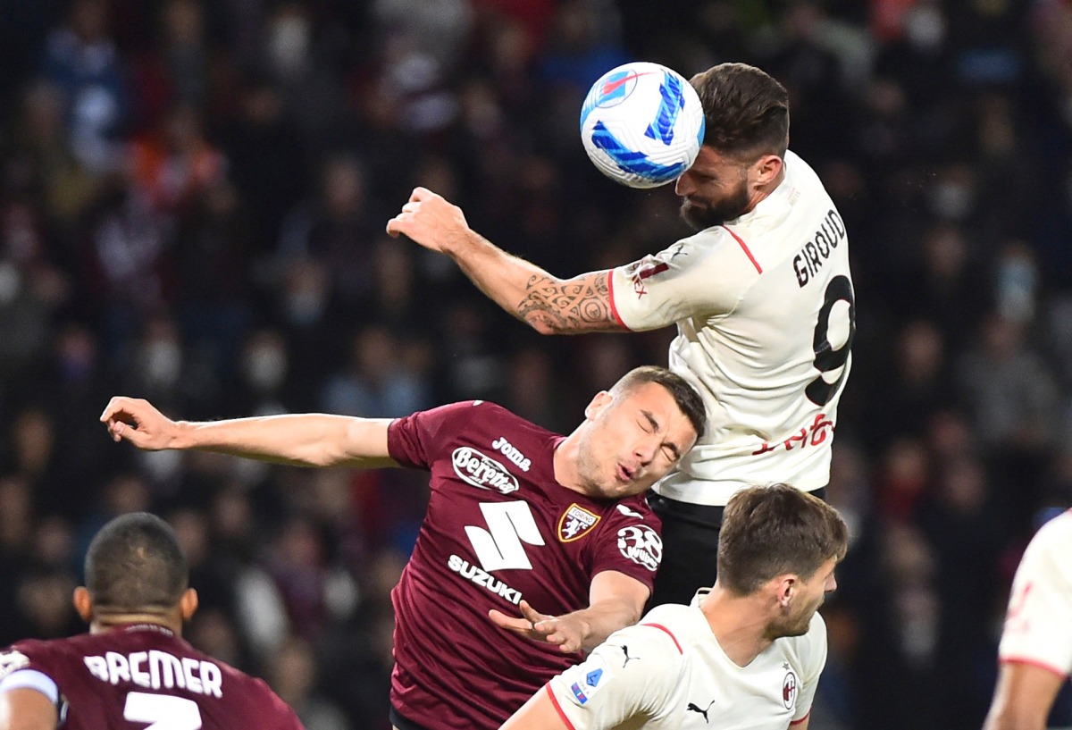 AC Milan's Olivier Giroud in action with Torino's Alessandro Buongiorno REUTERS/Massimo Pinca