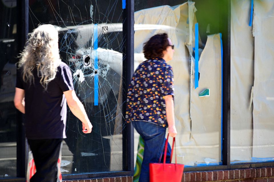 People walk past a damaged store window at a crime scene after a deadly mass shooting on South Street in Philadelphia, Pennsylvania, U.S., June 5, 2022. REUTERS/Bastiaan Slabbers


