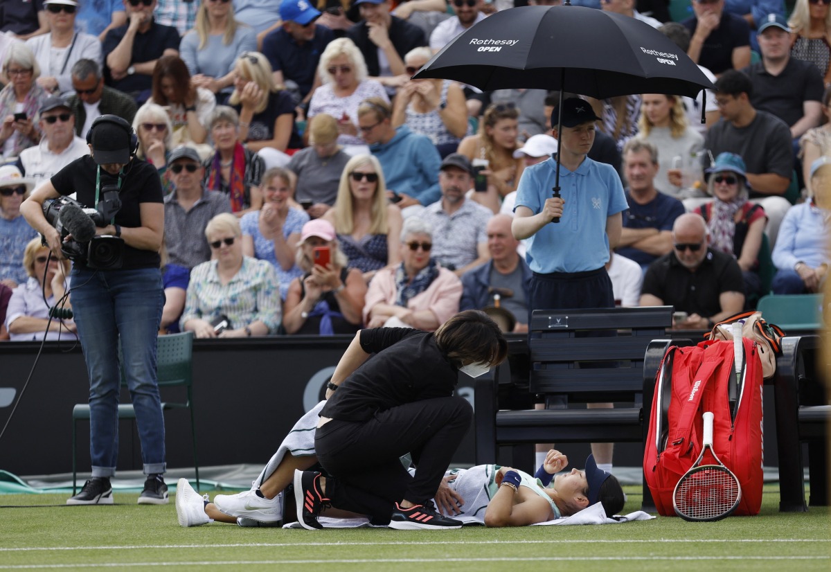 Britain's Emma Raducanu receives medical attention during her first round match against Switzerland's Viktorija Golubic Action Images via Reuters/Jason Cairnduff
