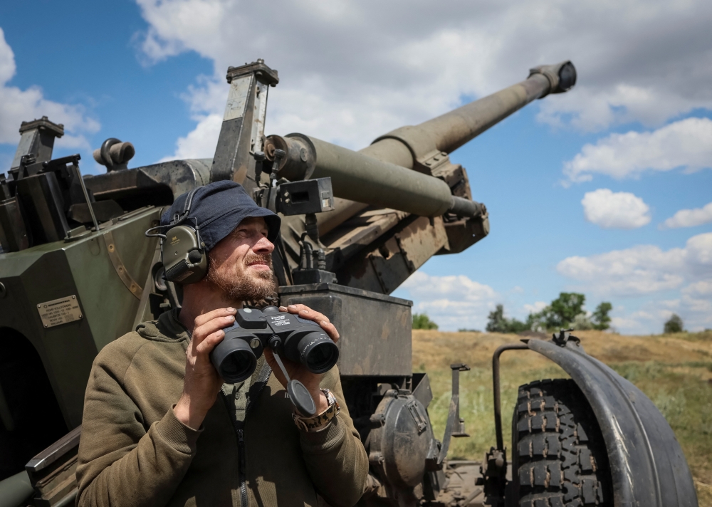 A Ukrainian service member checks an area after a shooting from a towed howitzer FH-70 at a front line, as Russia's attack on Ukraine continues, in Donbas Region, Ukraine, July 18, 2022. (REUTERS/Gleb Garanich)