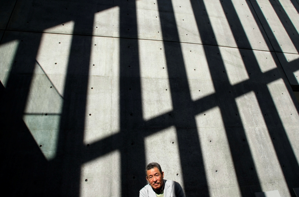 Japanese designer Issey Miyake poses at a photo opportunity at the exhibition 