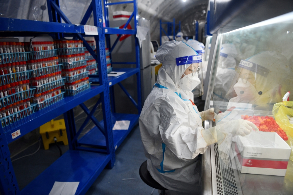 Staff members of Sichuan Provincial People's Hospital test nucleic acid samples inside a mobile laboratory set up at a sports centre, following the coronavirus disease (COVID-19) outbreak in Chengdu, Sichuan province, China September 4, 2022. cnsphoto via REUTERS